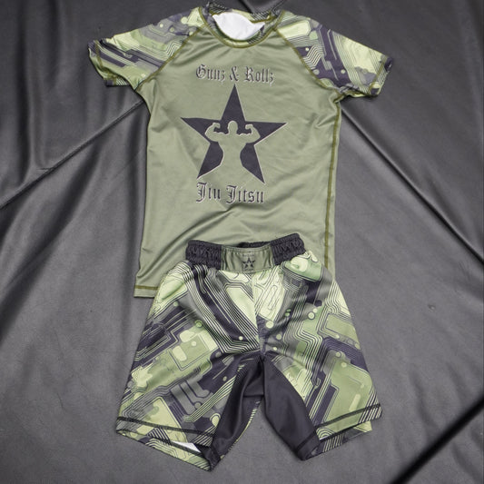 Green Gunz & Rollz kids' ranked camo rash guard with star logo, green body with green camo sleeves, flat-lay photo with matching shorts