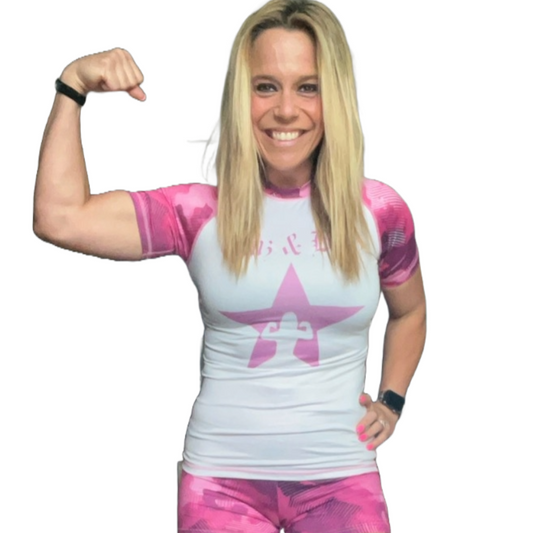 Model wearing white Gunz & Bunz women's pink camo rash guard, front view